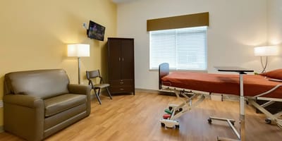 A private resident room with a bed and seating area