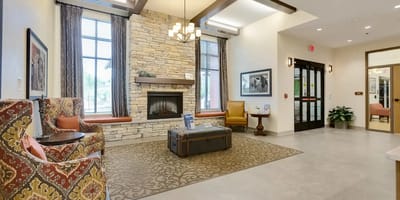 Bright lobby area with seating and a fireplace