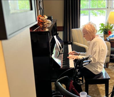 Resident playing piano in an activity room