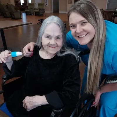 Staff member posing with a resident in a facility