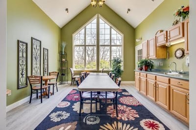 Bright dining area with large windows and colorful decor