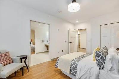 A well-furnished private resident room with bed and seating