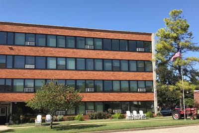 Exterior view of Ash Street Place with outdoor seating and flag