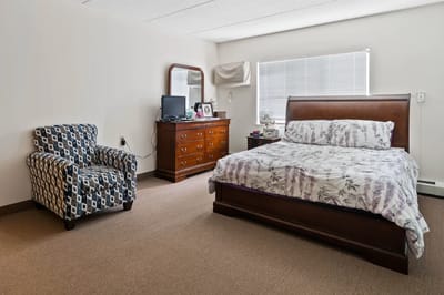 Cozy resident room with a bed and chair