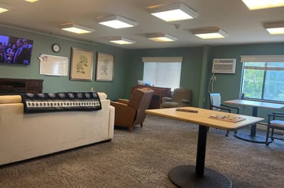 Common area with seating and a TV in the facility