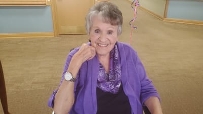 Resident smiling while seated indoors