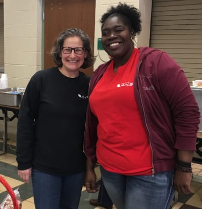 Two smiling staff members in a dining area