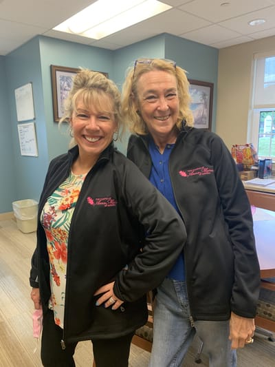 Two staff members posing in the common area