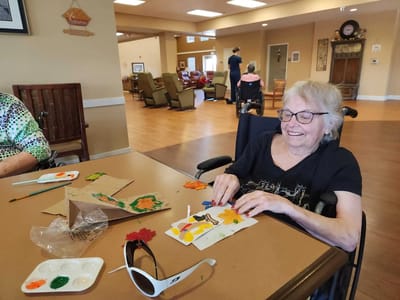 A resident engaging in a craft activity at a table