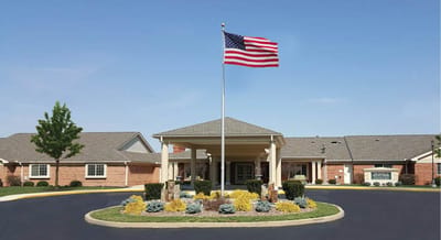 Exterior view of a senior living facility with American flag