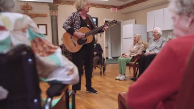 Musician performing for residents in an activity room