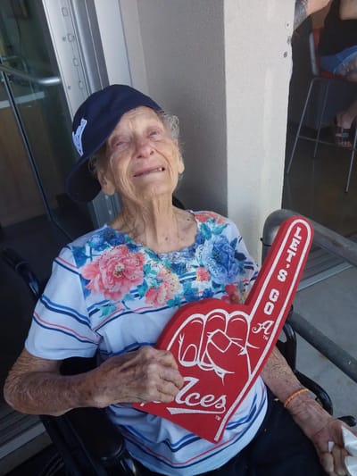 Resident holding a foam finger and smiling