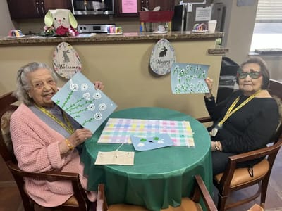 Two residents crafting and displaying their artwork