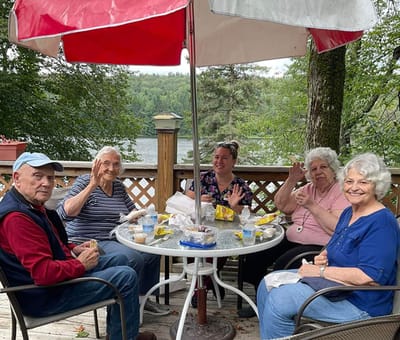Residents enjoying a meal outdoors by the lake