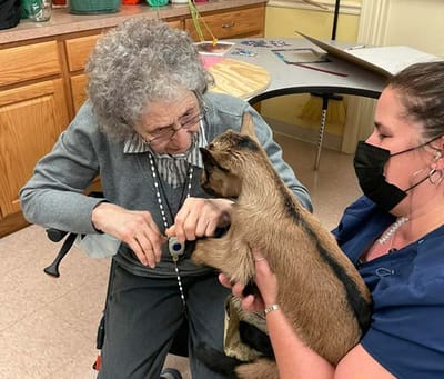 Resident interacting with a therapy animal indoors