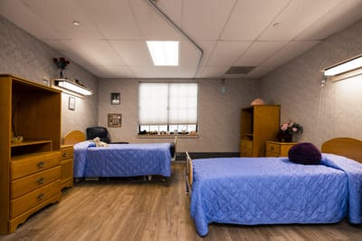 A shared resident room with two beds and personal items