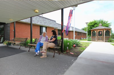 Residents chatting on a bench outside the facility