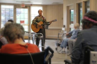 Musician performing for residents in an activity room