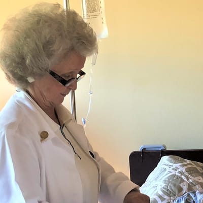 Nurse assisting a resident in a care room