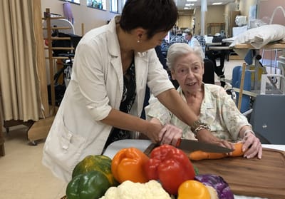 Staff assisting a resident with food preparation
