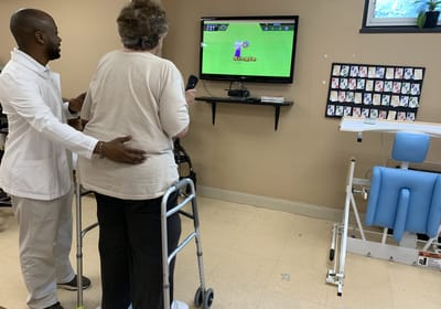 Staff assisting a resident with a gaming activity