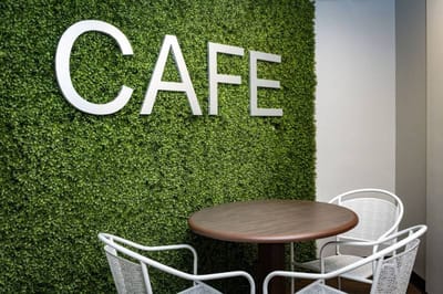 Interior view of a cafe with greenery wall decor