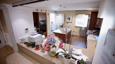 Inside view of a dining area with flowers and kitchen equipment