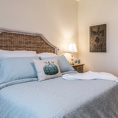 Cozy bedroom with a light blue quilt and decorative pillow