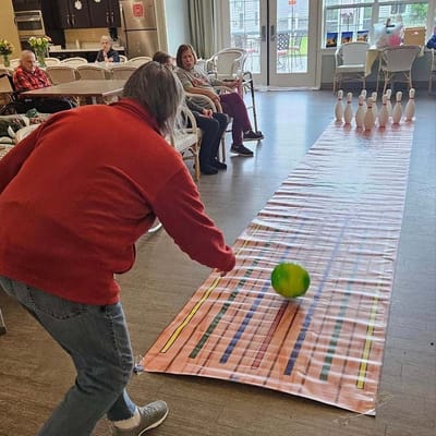 Resident participating in a bowling activity inside the facility