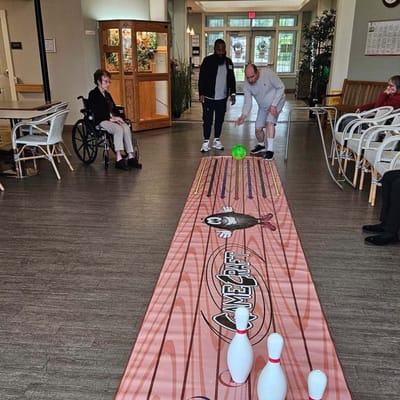 Residents participating in a bowling activity in a common area