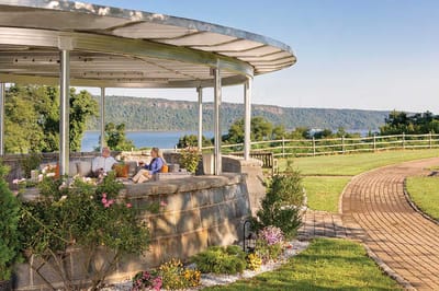 RiverSpring Living, nursing home in Bronx, NY — Seniors relaxing on a patio with scenic river view