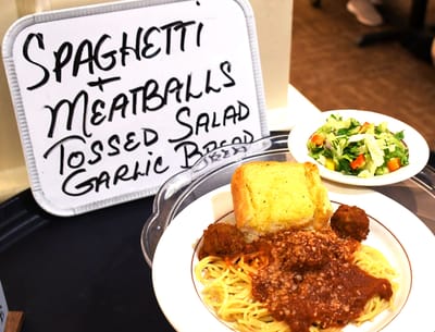 Plate of spaghetti and meatballs with salad and garlic bread