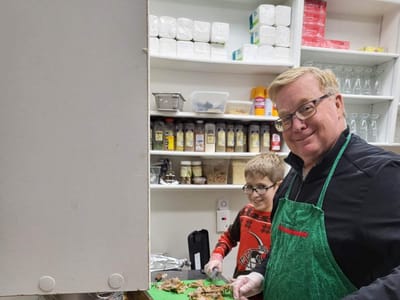 A man and a child preparing food in a kitchen