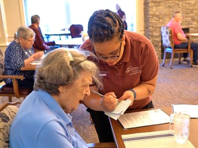 Staff assisting a resident in the dining area