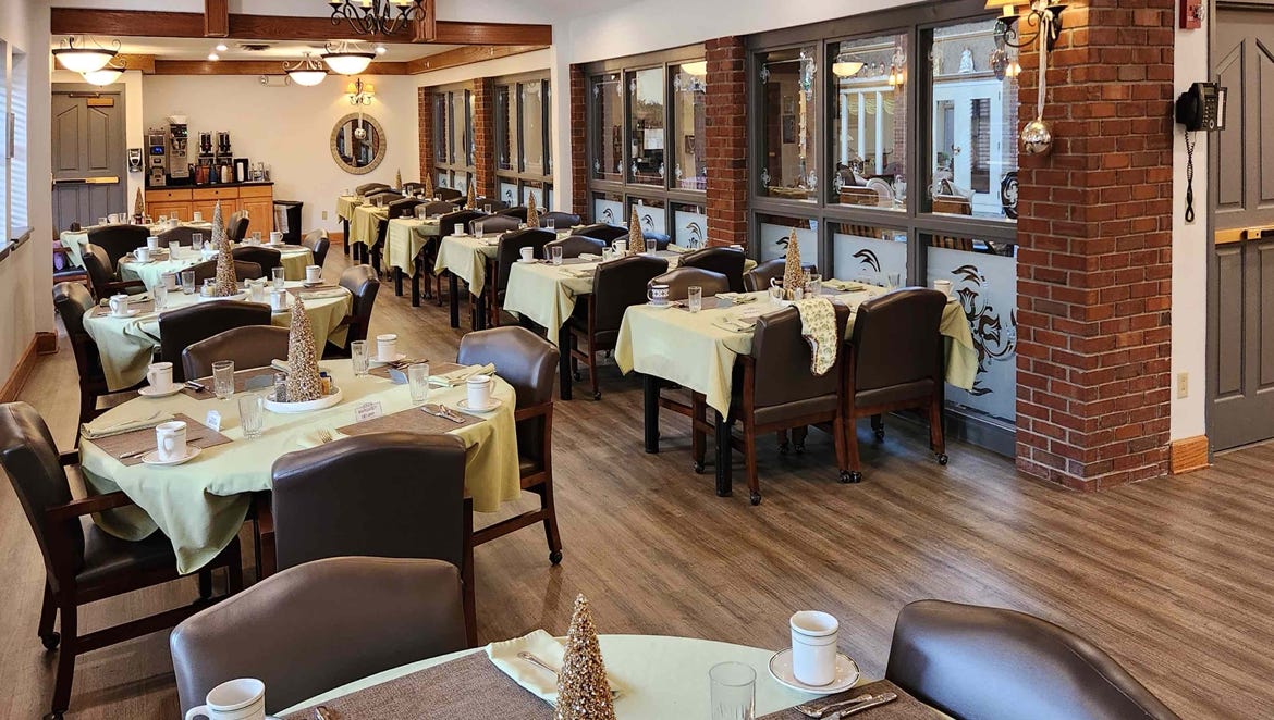 Dining area with tables and chairs set for residents
