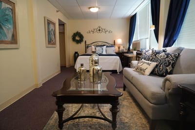 Well-decorated resident room with bed and seating area