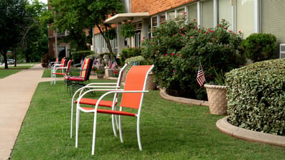 Outdoor seating with colorful chairs beside a pathway