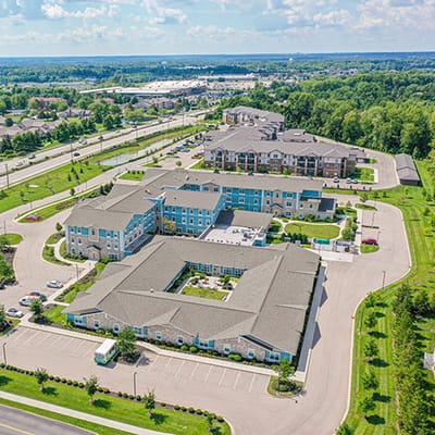 Aerial view of a senior living facility with landscaped grounds