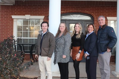 Staff members in front of the facility entrance.