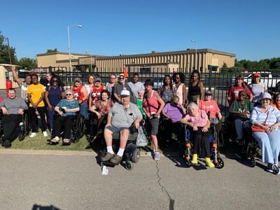 Group photo of residents and staff outside the facility