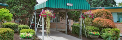 Entrance with landscaped pathway and colorful flowers