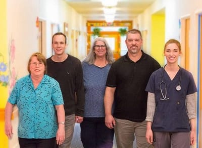 Staff and residents walking together in a brightly colored hallway