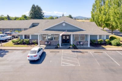 Exterior view of Bridgecreek Memory Care facility with a parking lot