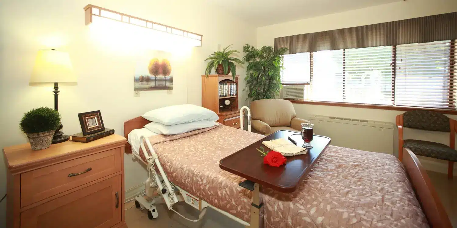 Cozy resident room with a bed, table, and plant