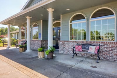 Exterior view of the facility entrance with benches and flowers