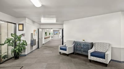 Bright, inviting hallway with comfortable seating and plants
