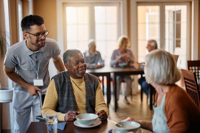 Staff serving meals to residents in a dining room