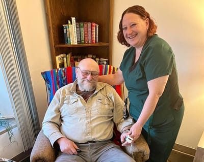 A staff member assisting a resident in a cozy setting