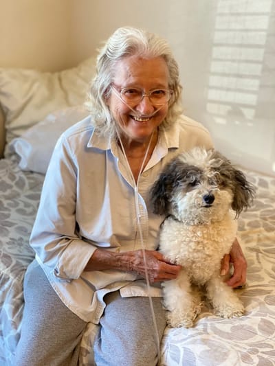 Smiling resident with a dog in a cozy room