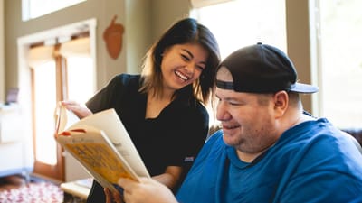 Staff member and resident sharing a book